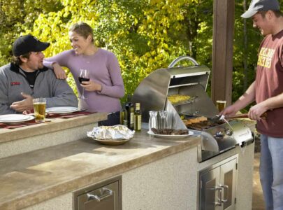 People drinking and grilling in outdoor kitchen